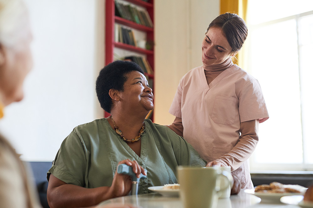 Smiling care worker and senior woman in care home