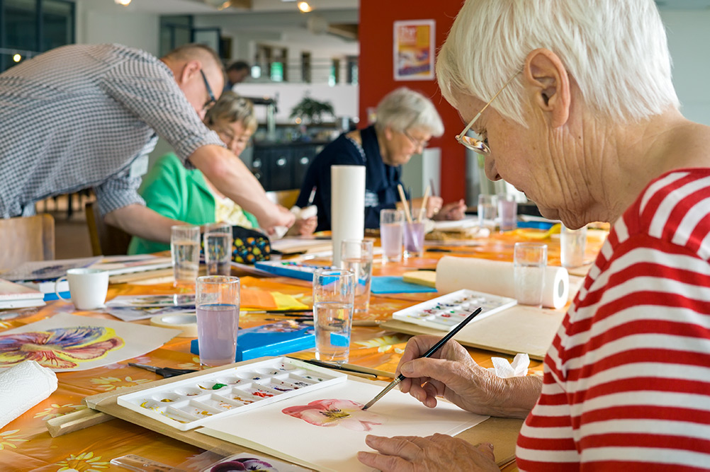 Care home elderly group painting together