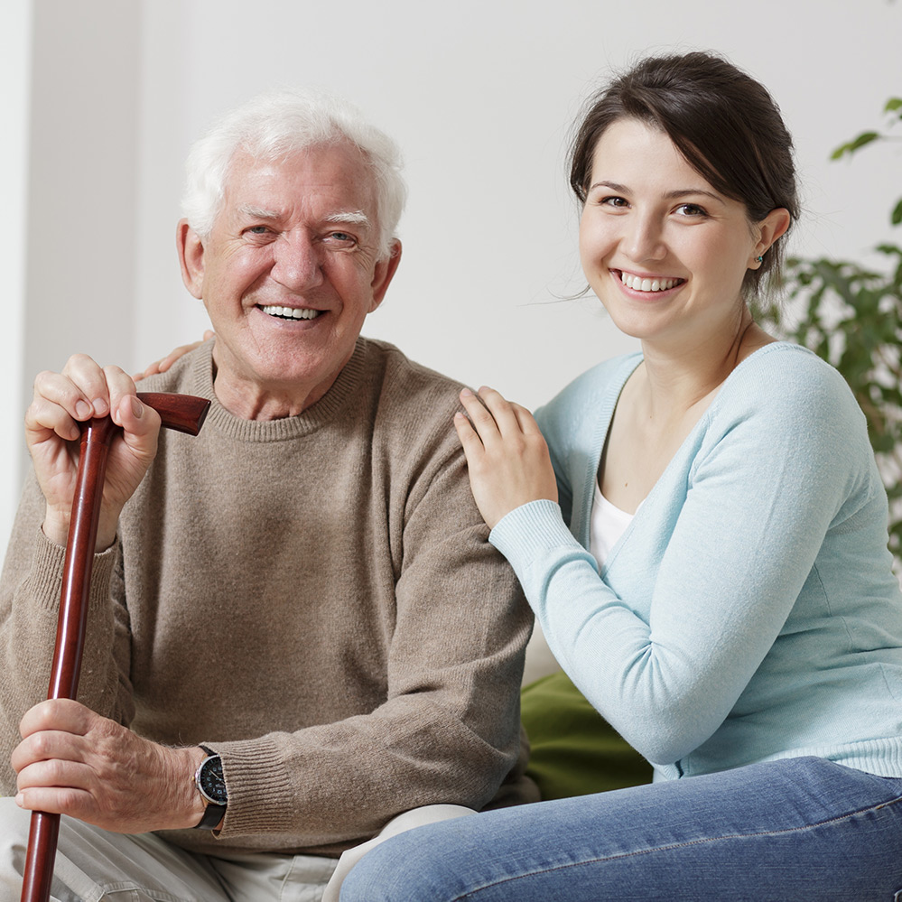 Senior man with cane and care worker smiling