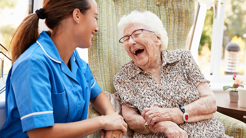 Smiling elderly woman laughing with carer